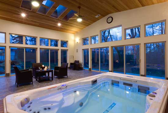 Nicely lit indoor space large windows with a swim spa