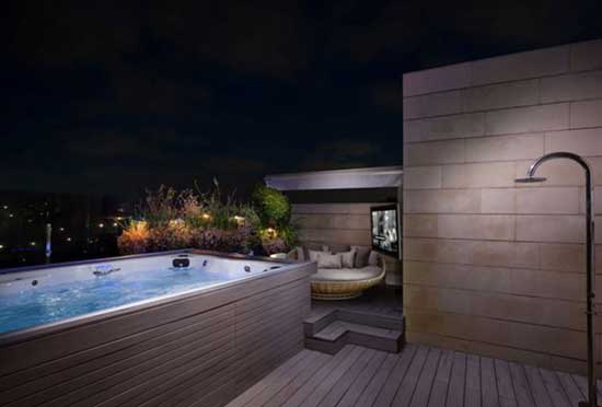 Nighttime view of swim spa on patio with shower